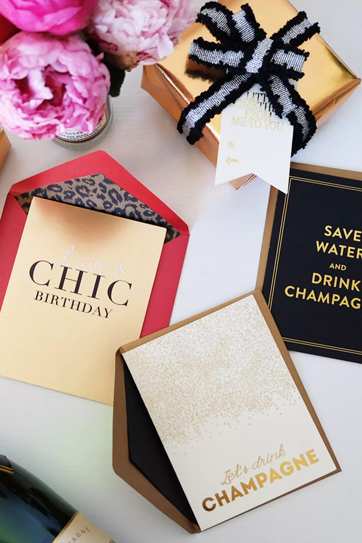 Decorative birthday cards with gold and black text on a white surface.