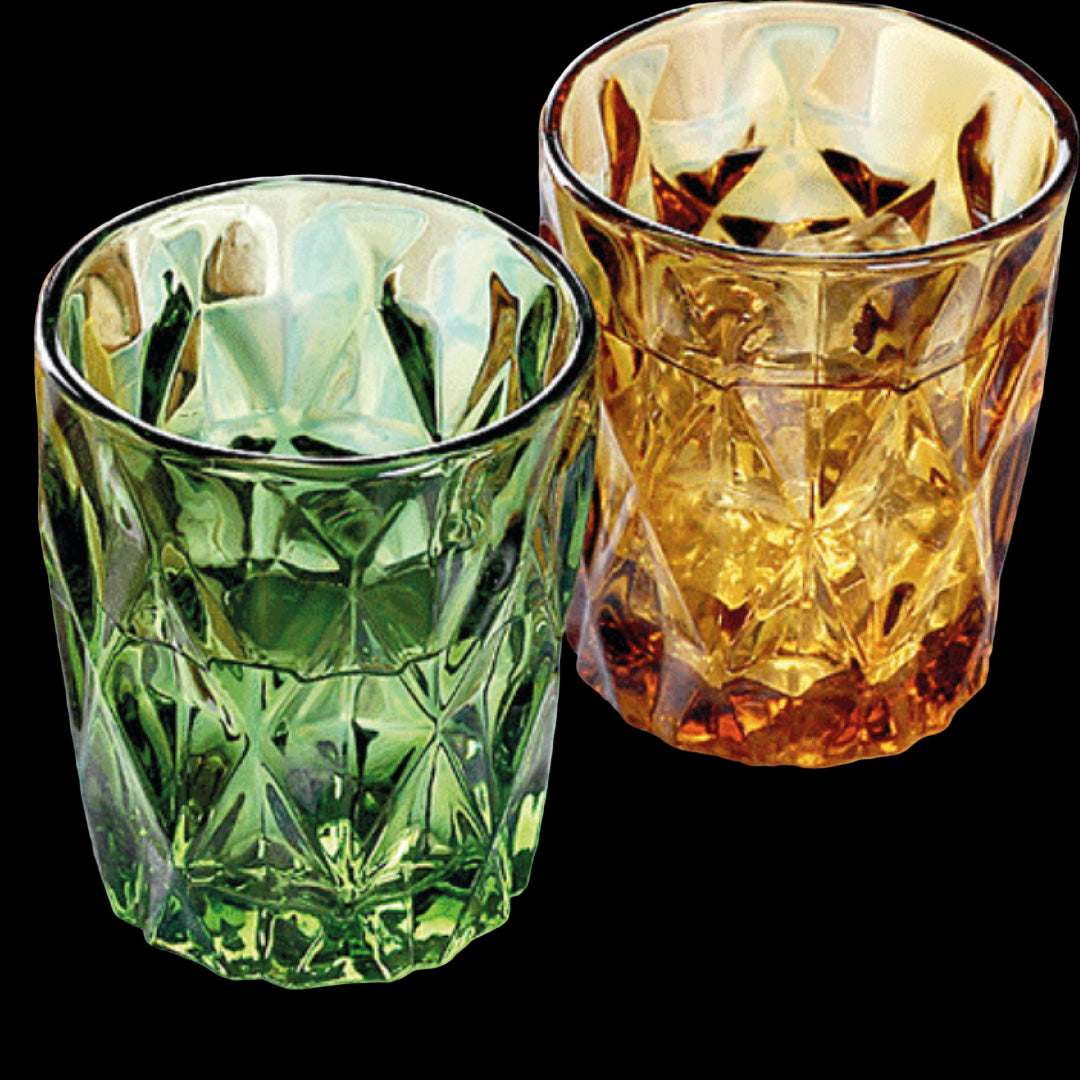 Two green and amber glass tumblers on a checkered tablecloth.