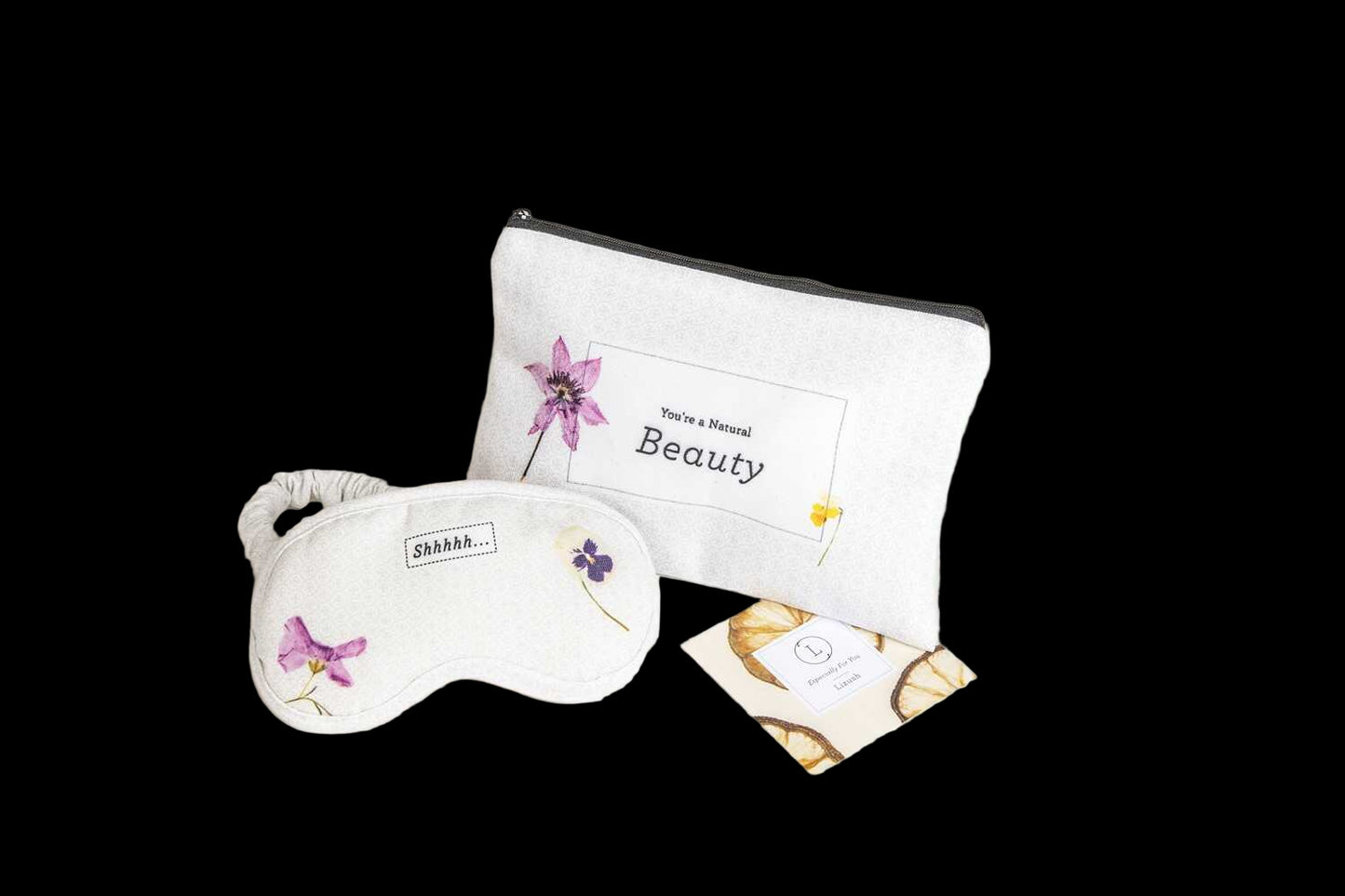 Sleep mask and pouch with floral designs on a white background