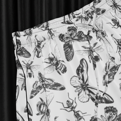 Pants with a black and white insect pattern on a light background