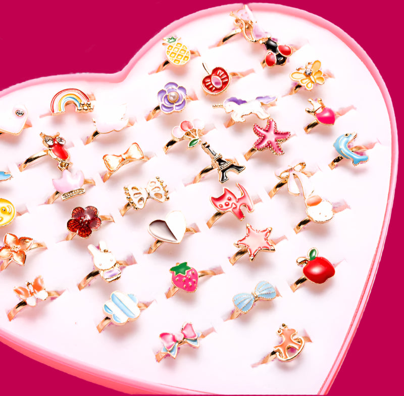 Collection of small decorative rings on a heart-shaped pink tray