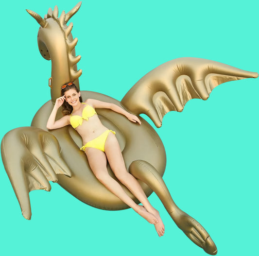 Woman in yellow bikini lying on a gold inflatable dragon pool float against a white background