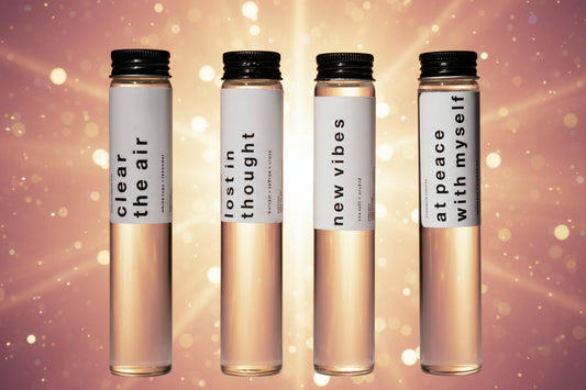 Four small bottles with labels on a dark background