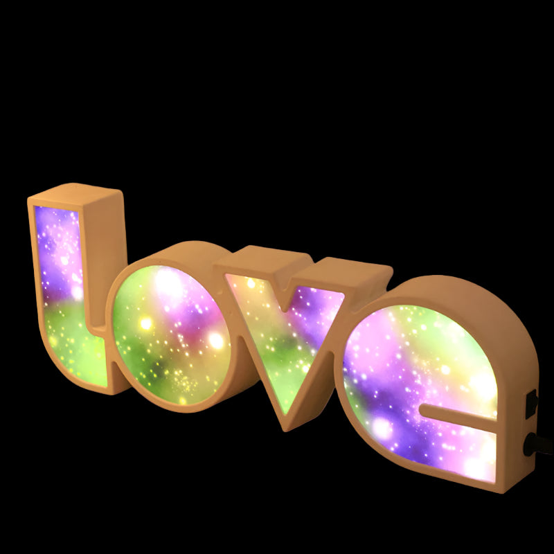 Colorful 'LOVE' letter lights on a wooden surface with a blurred background