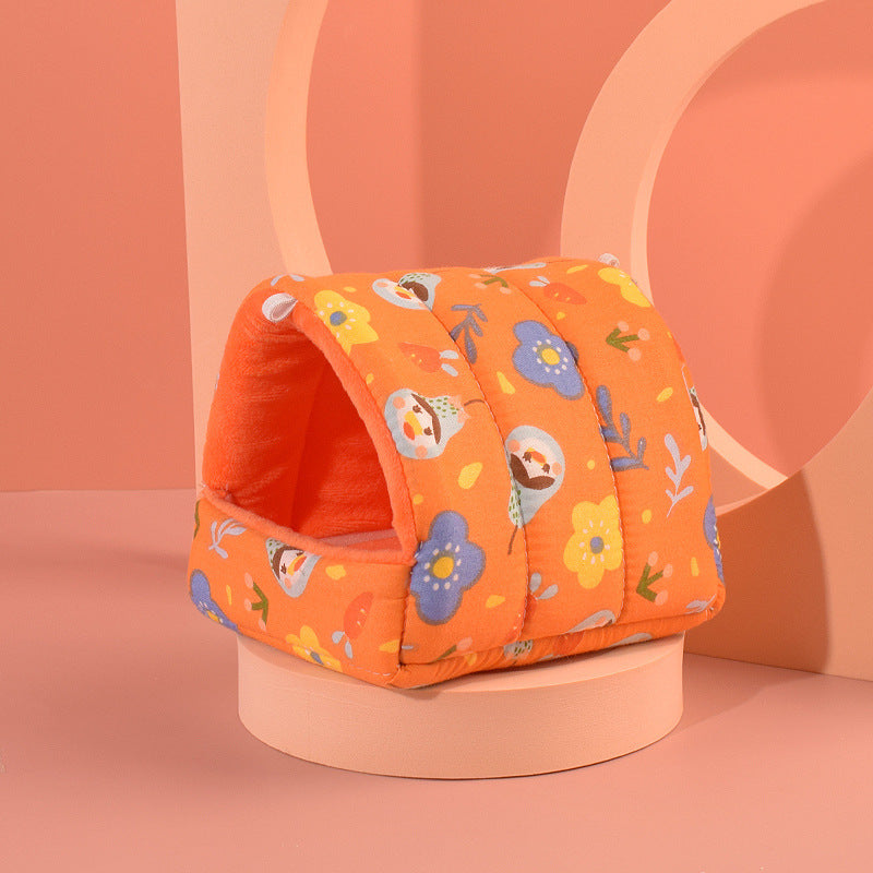 Orange pet bed with floral pattern on a peach-colored background