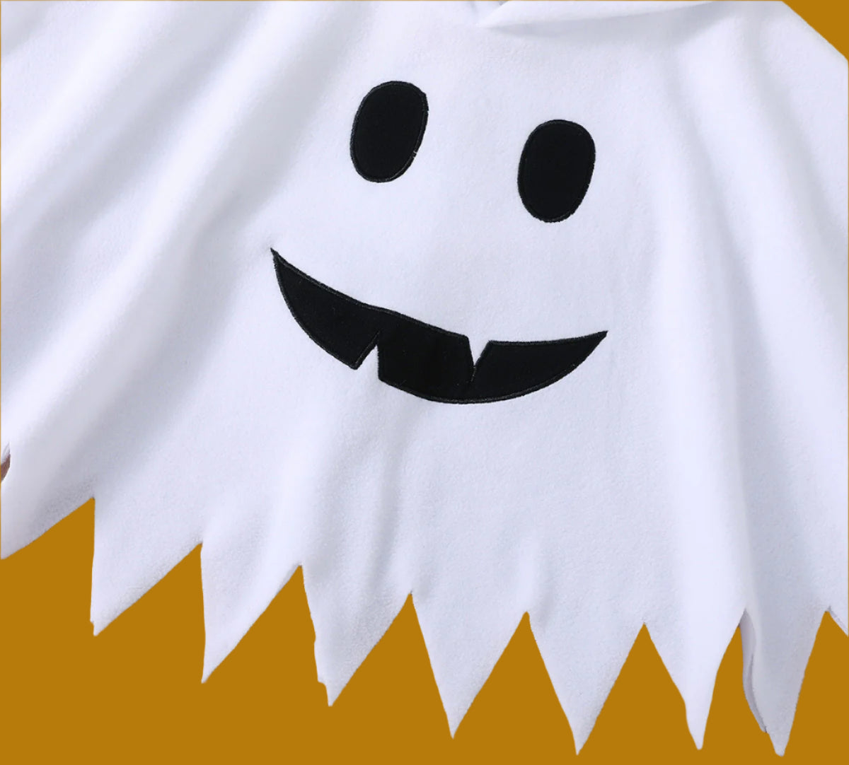 White ghost costume with black eyes and mouth on a wooden surface