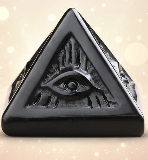 Black pyramid-shaped ring with eye design on a white background