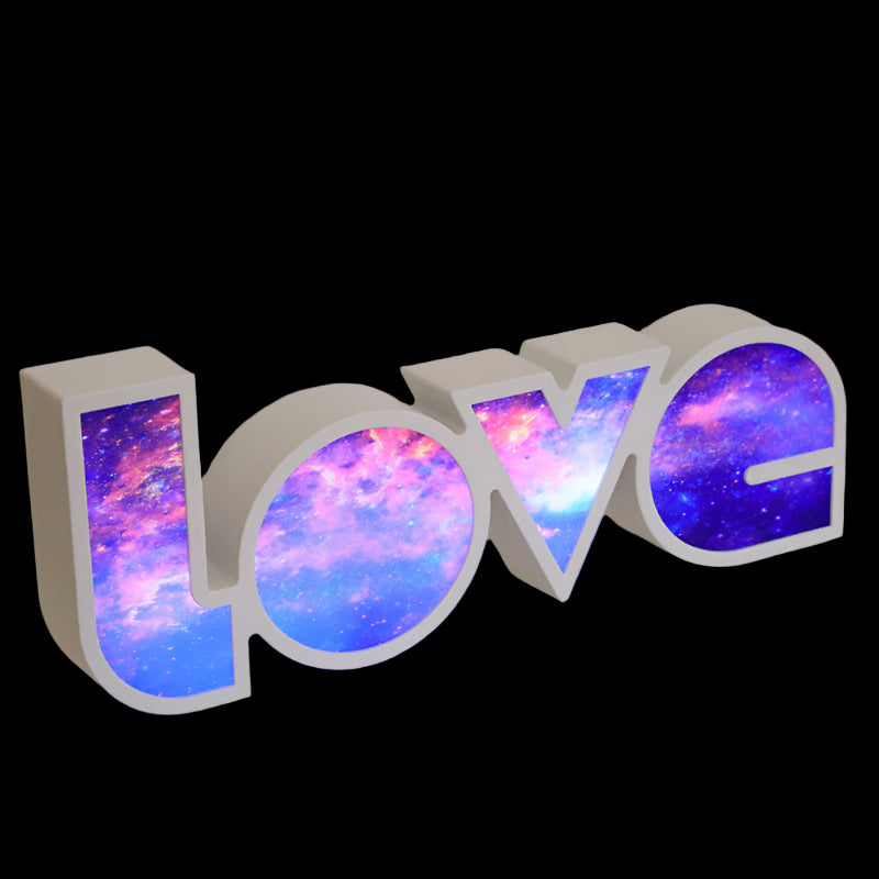 Decorative letters spelling 'LOVE' with a colorful galaxy design on a textured surface.