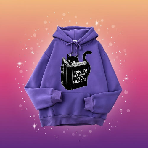 Purple hoodie with a black cat illustration and text on a table.