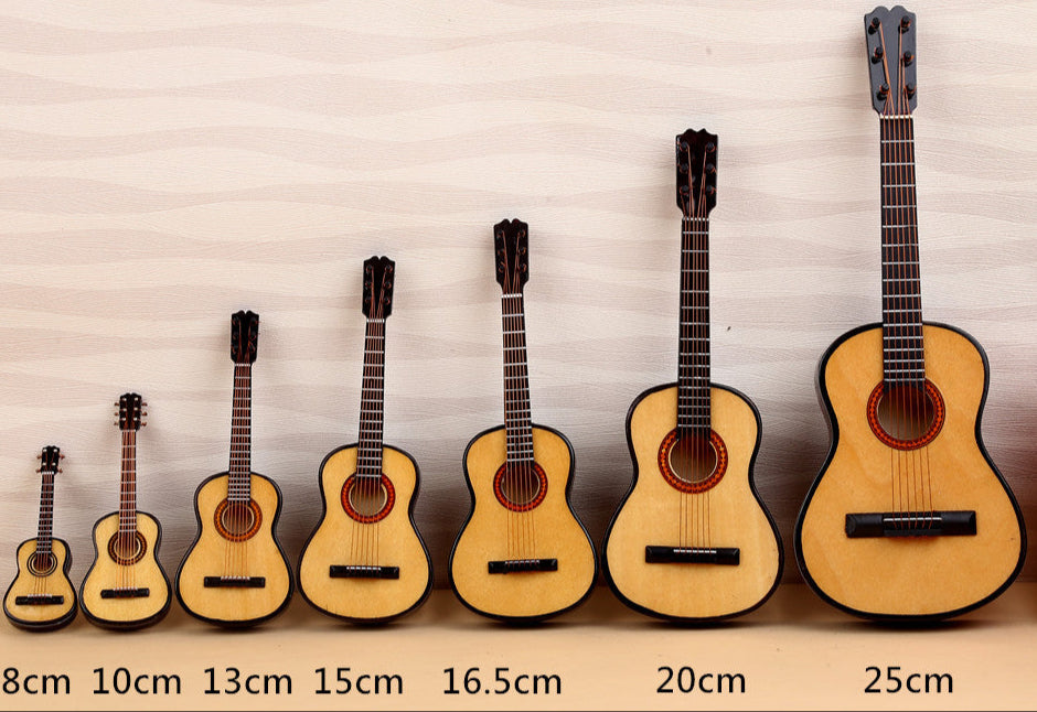 Set of miniature guitars displayed next to a can of Diet Coke for size comparison.