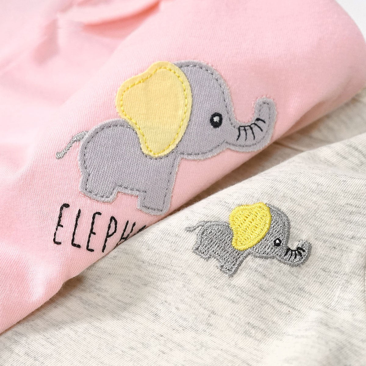 Two elephant patches on a pink and beige fabric background