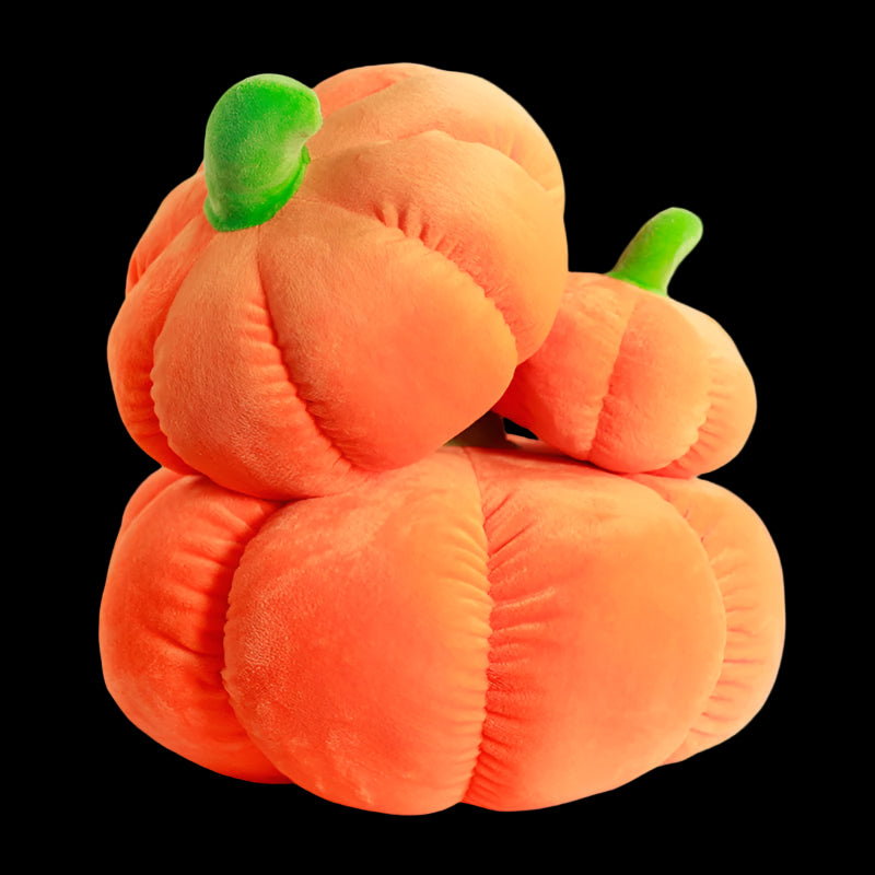 Stack of plush pumpkins on a tiled surface with a blurred indoor background
