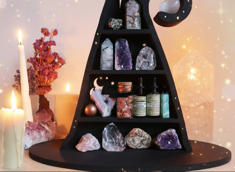 Black tiered shelf with crystals, candles, and bottles against a warm-toned background