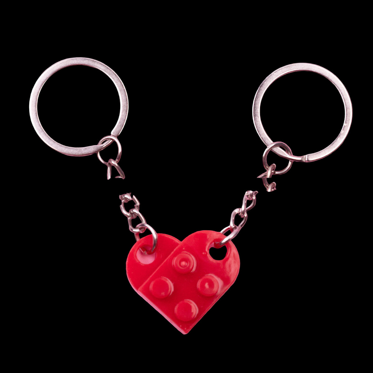 Red heart-shaped keychain with silver rings on a pink background