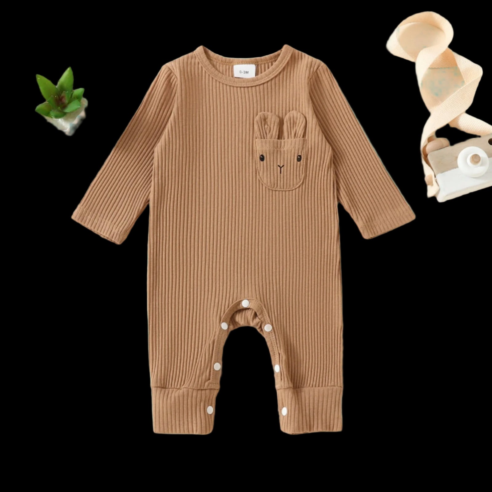 Brown ribbed baby onesie with bunny ears and nose on a beige background