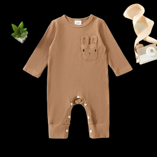 Brown ribbed baby onesie with bunny ears and nose on a beige background