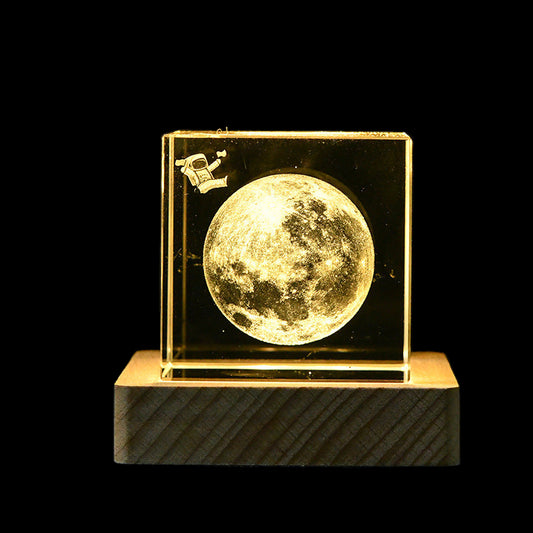 Decorative moon lamp with a spacecraft on a dark background
