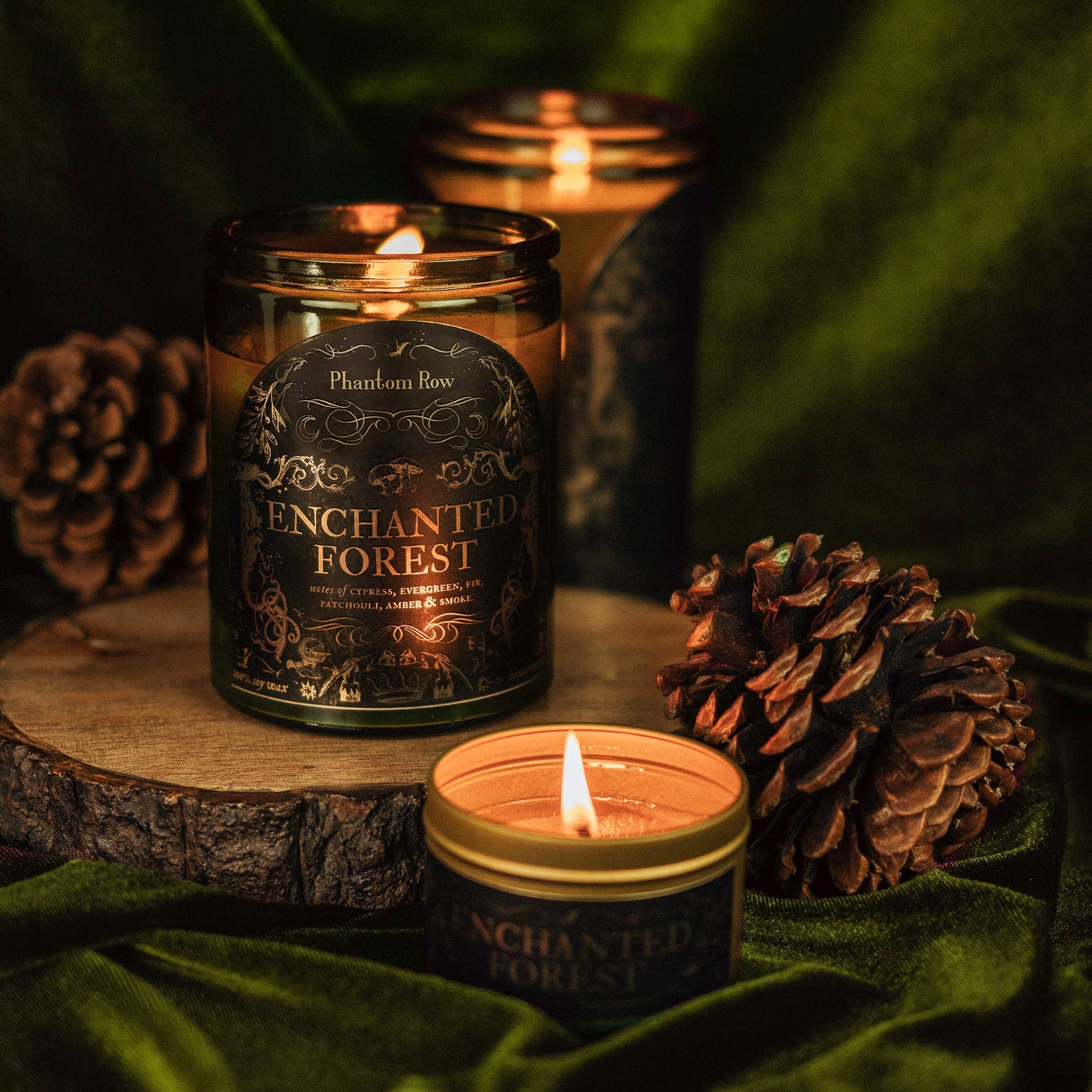 Candle with 'Enchanted Forest' label on a wooden surface with pinecones.