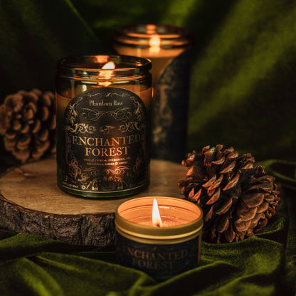 Candle with 'Enchanted Forest' label on a wooden surface with pinecones.
