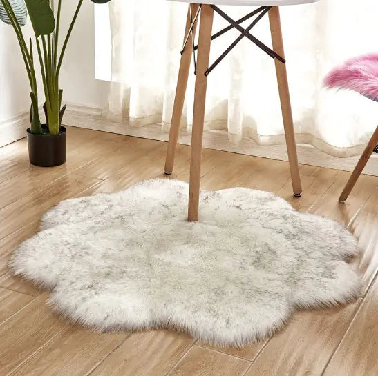 White fluffy rug on a wooden floor with a chair and plant in the background
