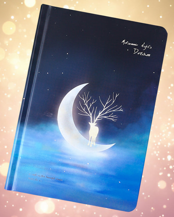 Notebook with a design of a deer on a crescent moon against a night sky, surrounded by confetti.
