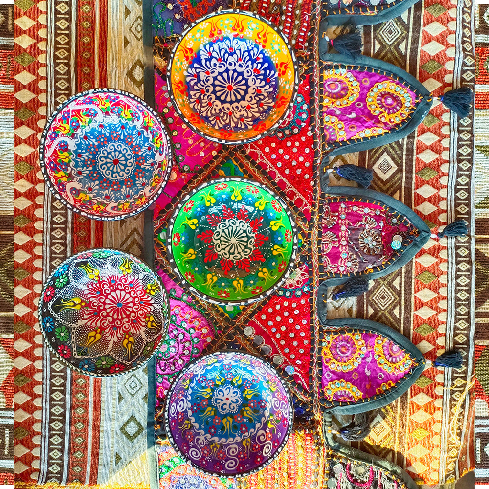 Colorful decorative plates on a patterned fabric background