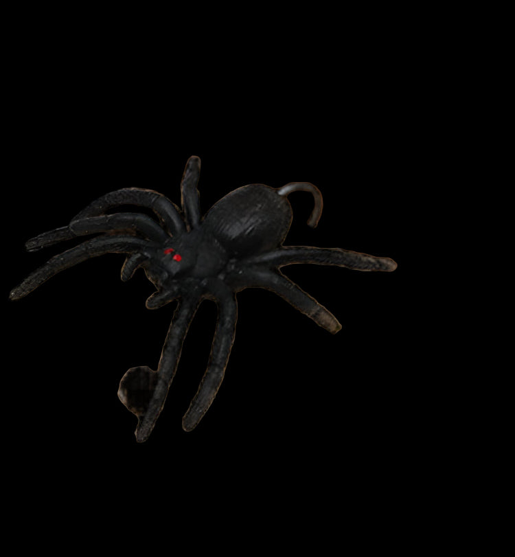 Black spider toy on a wooden surface