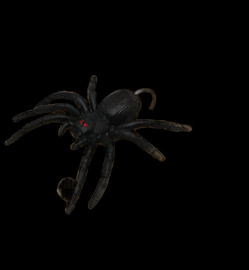Black spider toy on a wooden surface