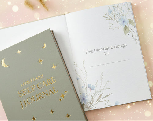 Two planners on a marble surface with one open to a page and a pen beside them.