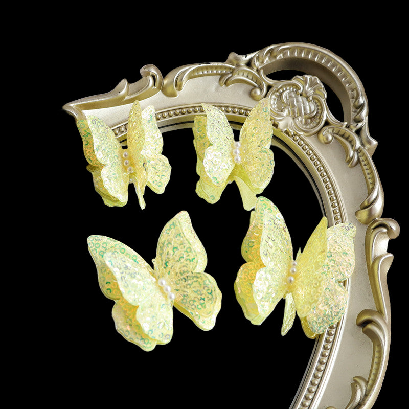 Yellow butterfly earrings on a decorative mirror with lace background