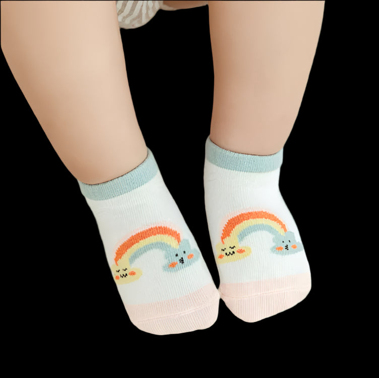 Children's socks with rainbow designs on a beige carpet