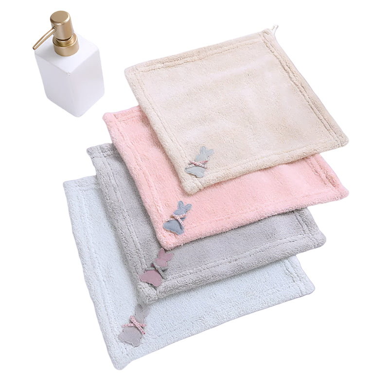 Set of three folded towels in beige, pink, and gray with butterfly designs on a white surface.