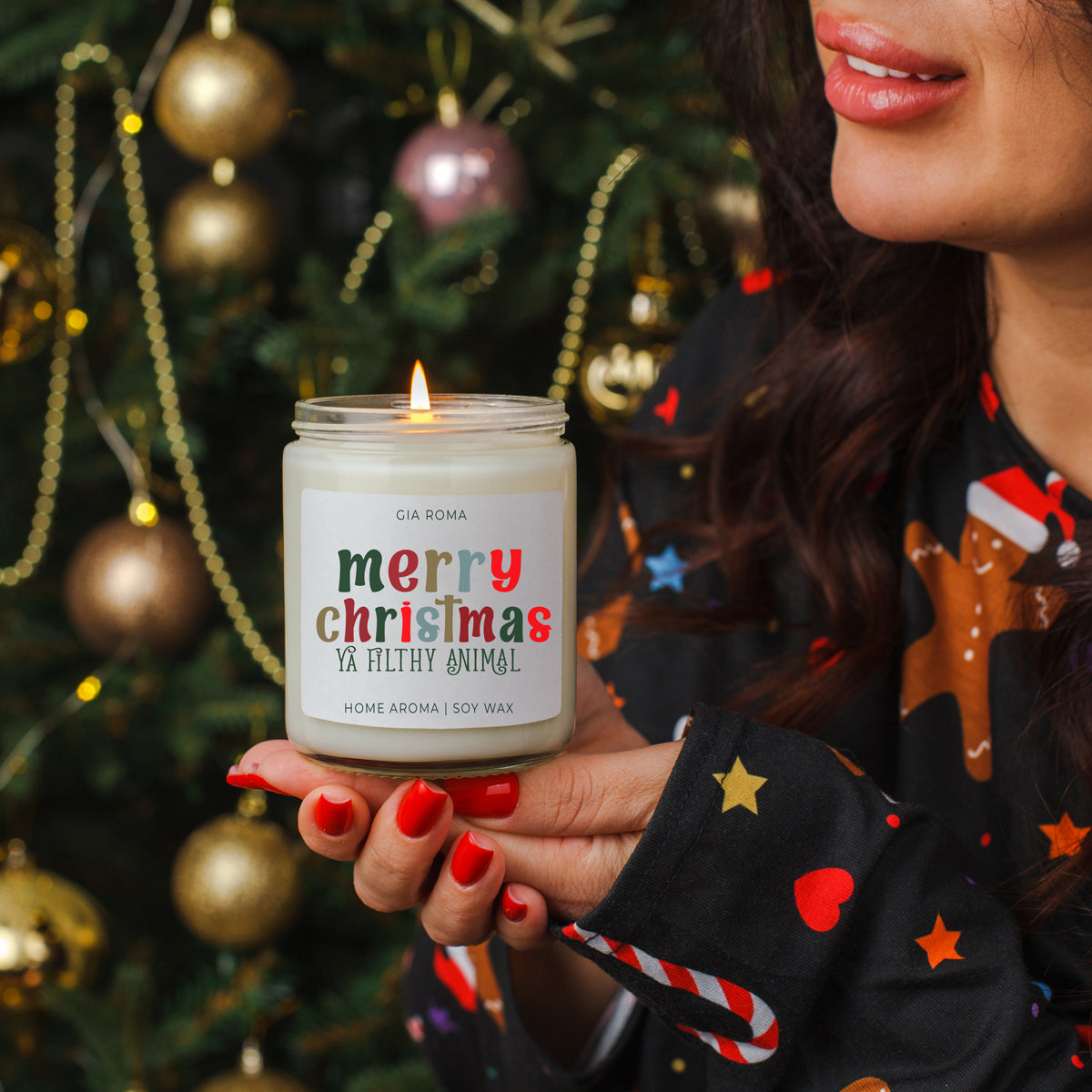Person holding a lit candle with a 'merry christmas ya filthy animal' label in front of a decorated Christmas tree.