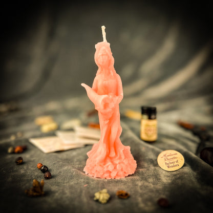 Pink statue candle on a dark surface with blurred background