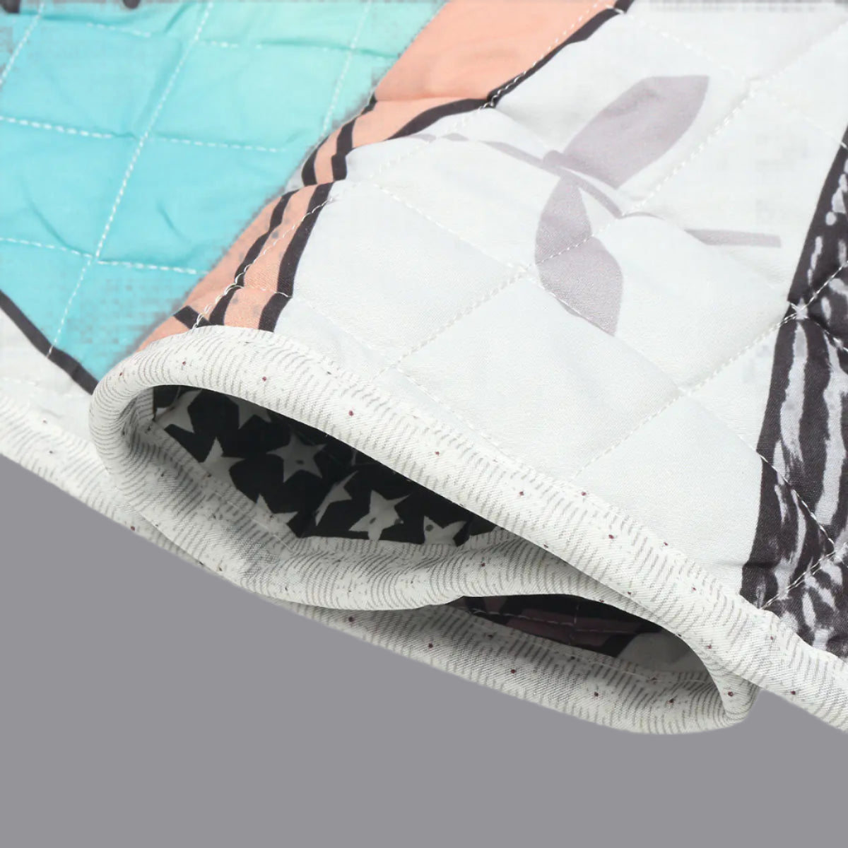 Close-up of a quilt with geometric patterns on a light blue background