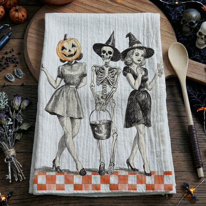 Halloween-themed towel with skeletons and pumpkins on a wooden surface.