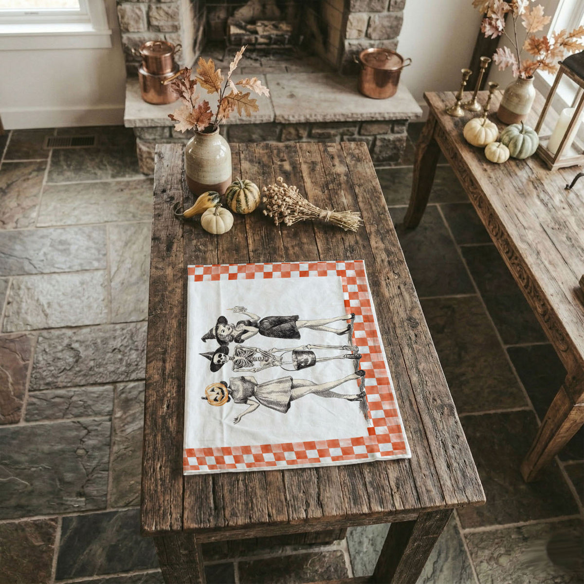 Wooden table with a decorative checkered cloth featuring people and dogs, in a cozy room with a fireplace.