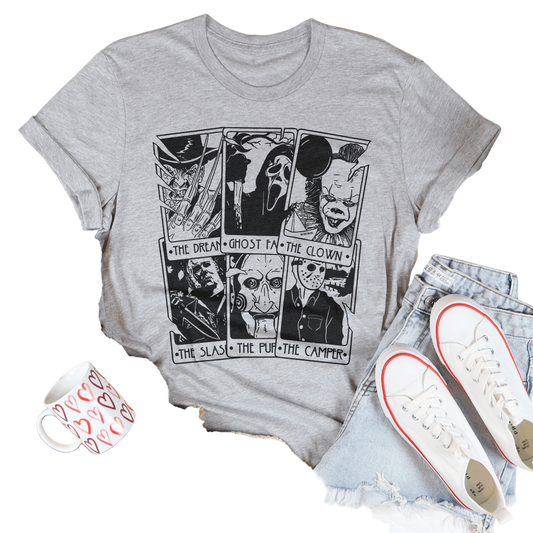 Gray t-shirt with graphic design on a white surface with casual items around