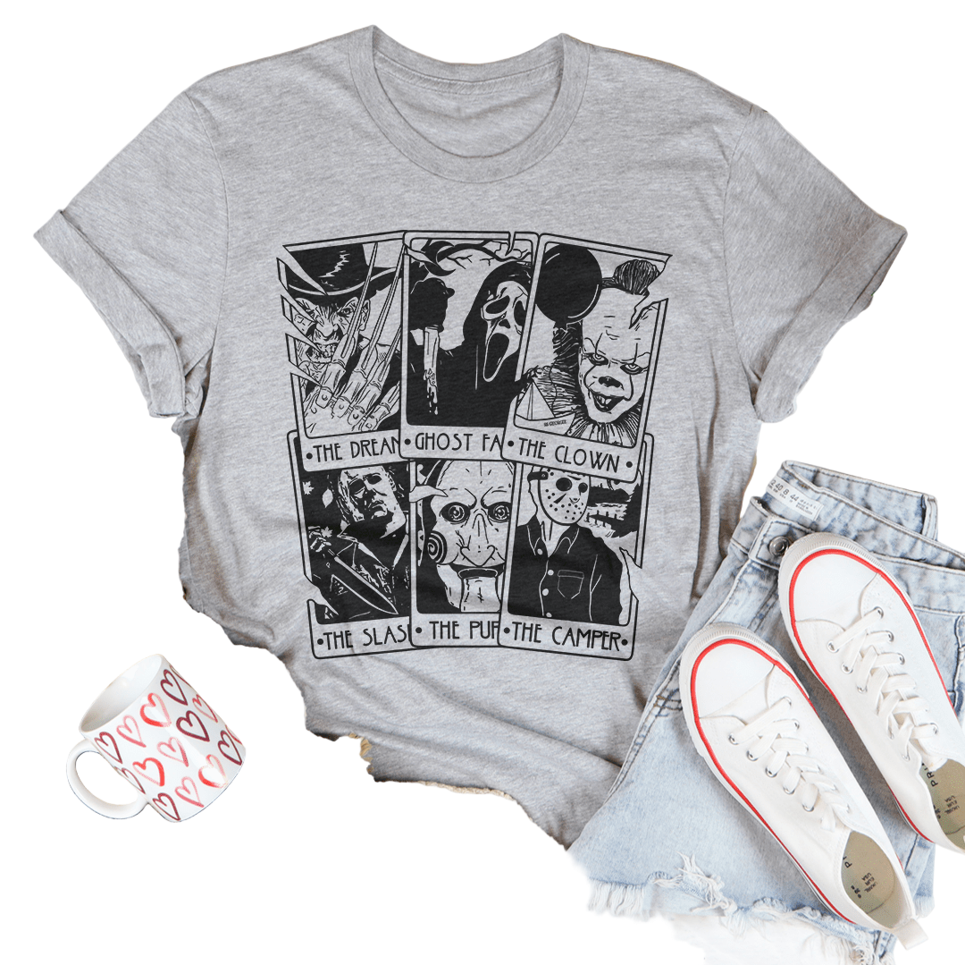 Gray t-shirt with graphic design on a white surface with casual items around