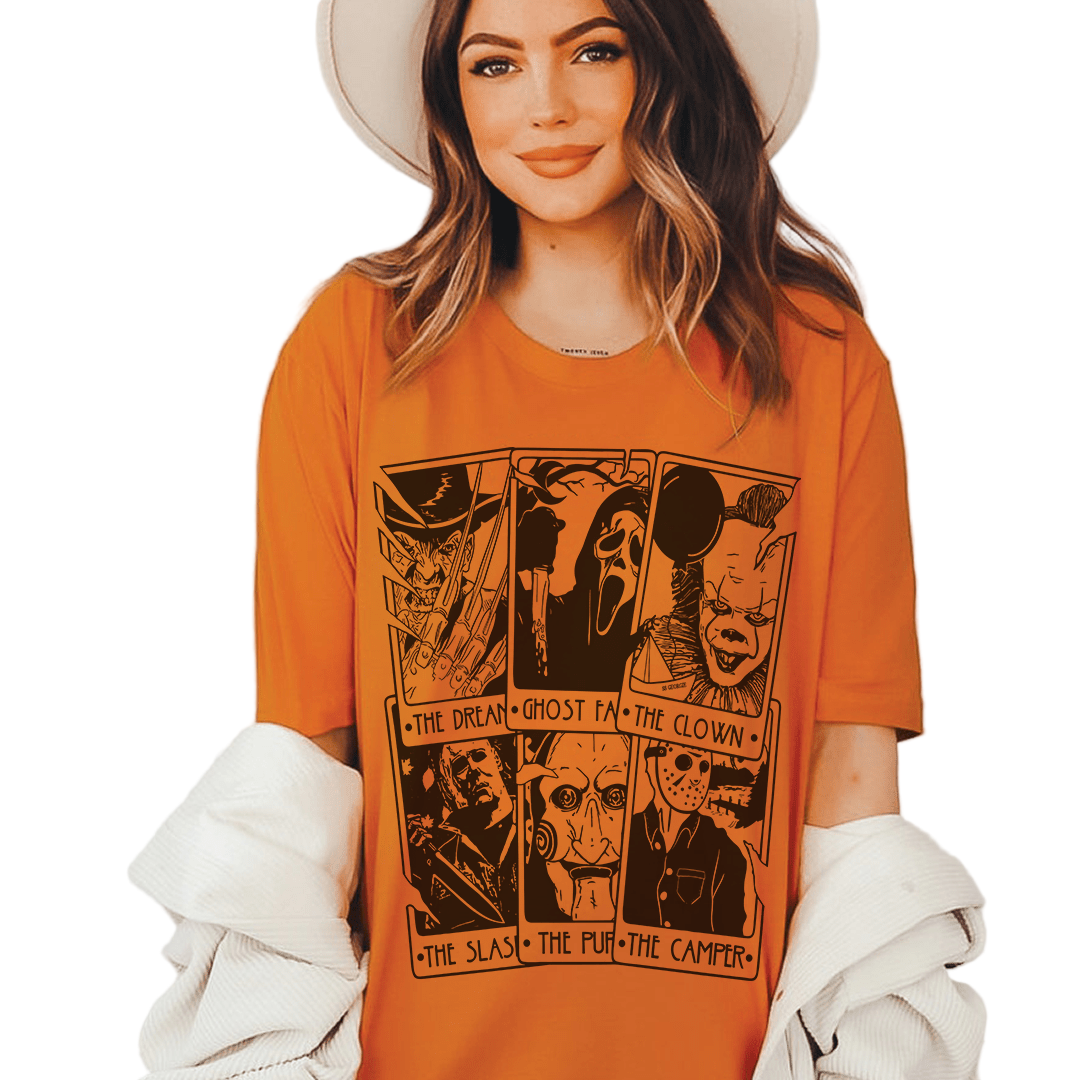 Woman wearing an orange t-shirt with graphic designs and text.