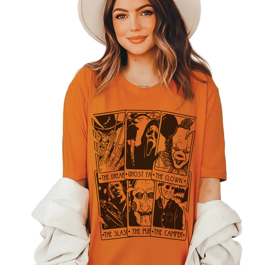 Woman wearing an orange t-shirt with graphic designs and text.