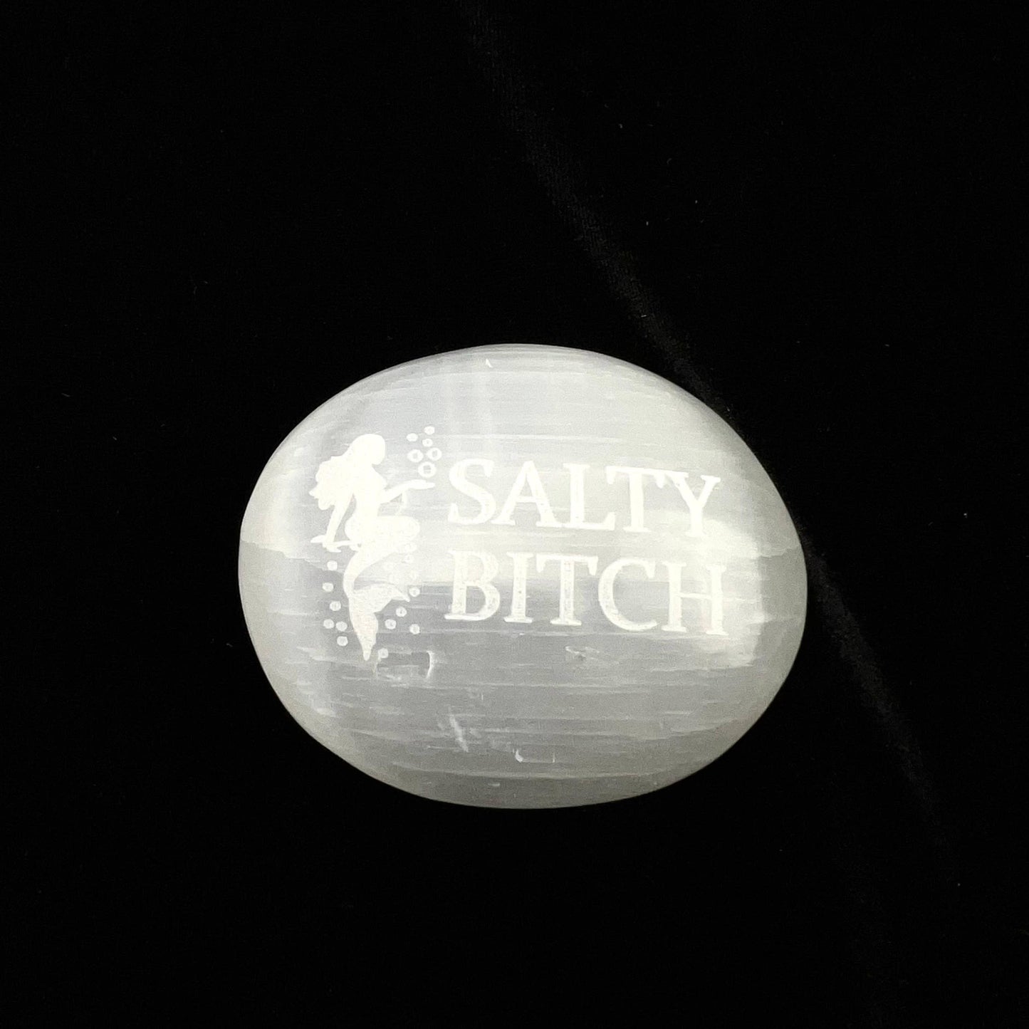 Round stone with 'SALTY BITCH' engraved on a black background