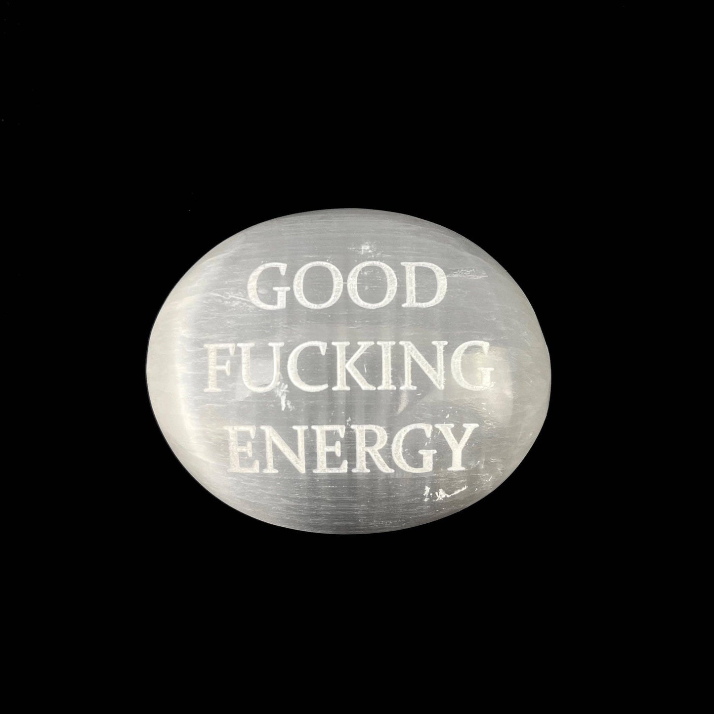 A round, semi-translucent white stone cabochon featuring the text 'GOOD FUCKING ENERGY' in a distressed white font, set against a solid black background.