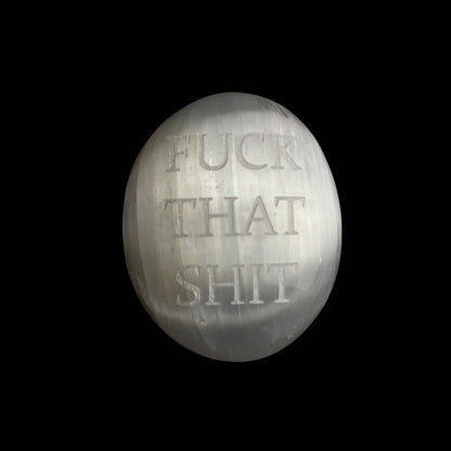 A round, metallic silver plaque or ornament engraved with the text 'FUCK THAT SHIT' in a serif font, set against a solid black background.