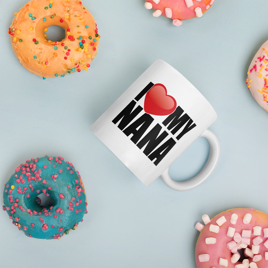 White mug with 'I ❤️ NANA' text surrounded by colorful donuts on a light blue background
