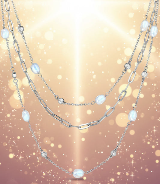 Layered silver chain necklace with moonstone beads on a white background