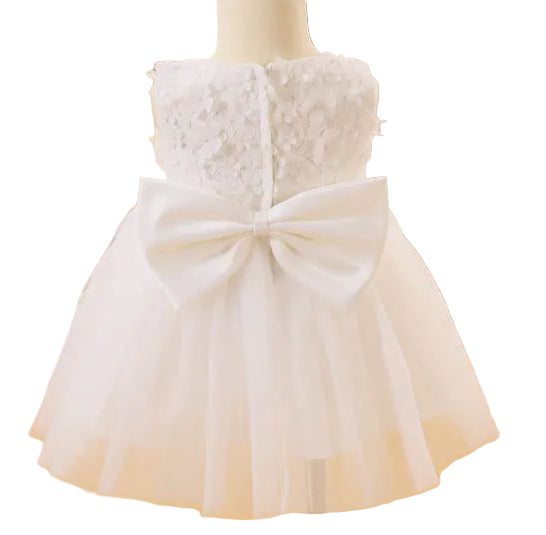 White lace dress with a large bow on a mannequin in a room setting.
