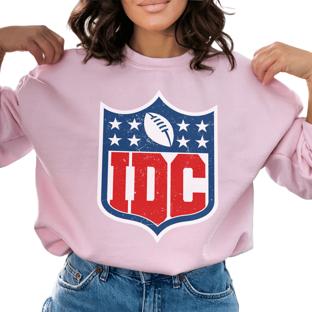 Person wearing a pink sweatshirt with a logo featuring 'IDC' letters.