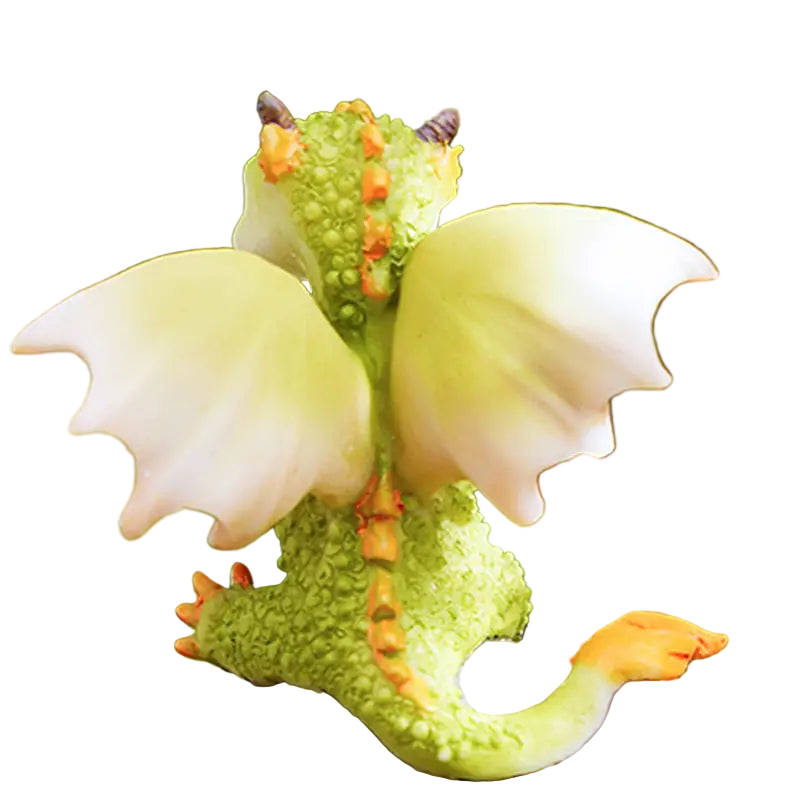 Small green dragon figurine with orange accents on a rock against a blurred green background