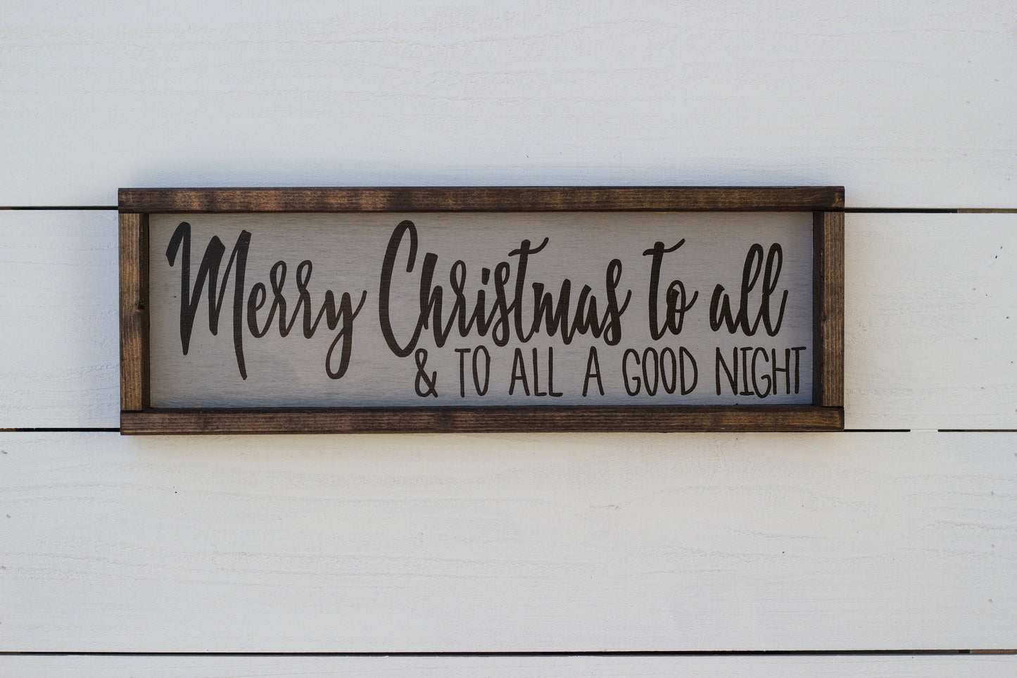 Wooden sign with 'Merry Christmas to all & to all a good night' text on a white wooden background